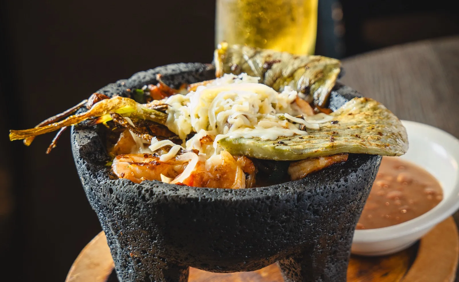 El Molcajete especial, shrimp and grilled meats in a lava-stone bowl